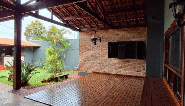 Casa com ares de campo na cidade. Deck com redes e bancos, jardim e quiosque.