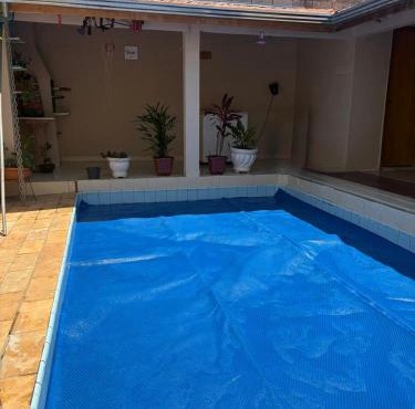 Casa inteira com três quartos, piscina climatizada por energia solar e área de churrasqueira