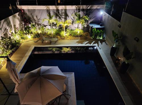 Suíte tripla com vista piscina em casa familiar de luxo em Itaipu